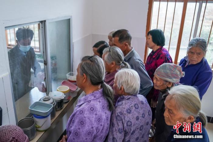 资料图：广西隆安县东信村“爸妈食堂”内，老人们排队取餐。 <a target='_blank' href='http://www.chinanews.com/'><p  align=