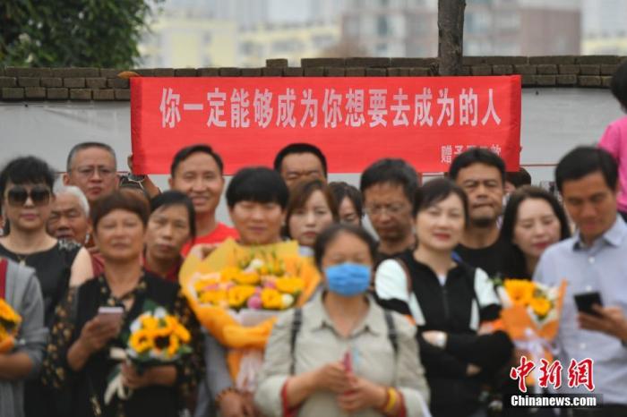 资料图：6月8日，云南省昆明市的考生结束2021年全国高考。图为考试结束后，一幅助考标语前有考生和家长合影留念。 <a target='_blank' href='http://www.chinanews.com/'><p  align=