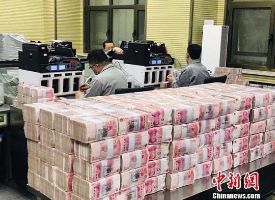資料圖：銀行點鈔員在工作。艾慶龍 攝