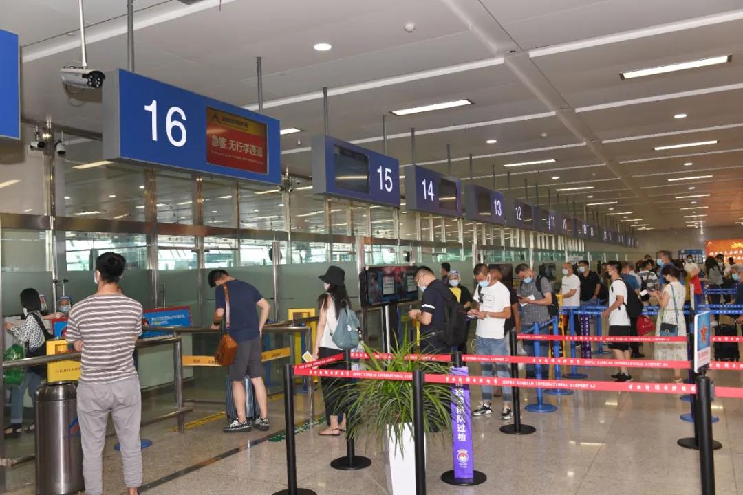 旅客在合肥新桥国际机场保持社交距离办理登机手续.