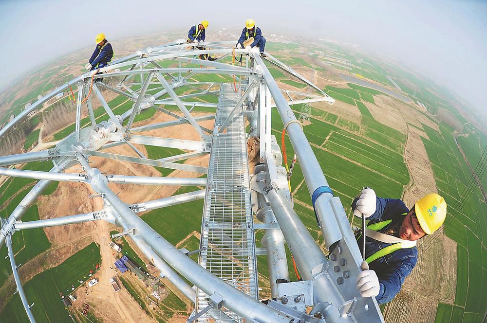 安徽送变电工程公司施工人员在80多米高空安装特高压输电铁塔